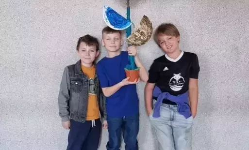 uczniowie z ekologicznym kwiatem
